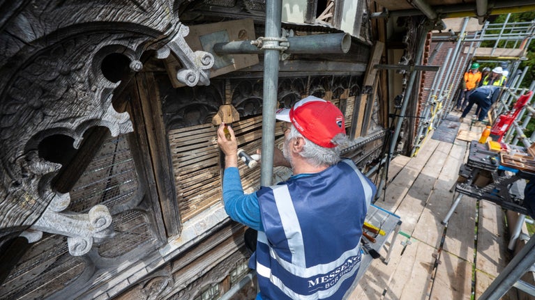 Terry, specialist woodcarver with building company Messenger, is on the scaffolding at Wightwick Manor, carving an intricate piece of wood decoration as part of the conservation project.